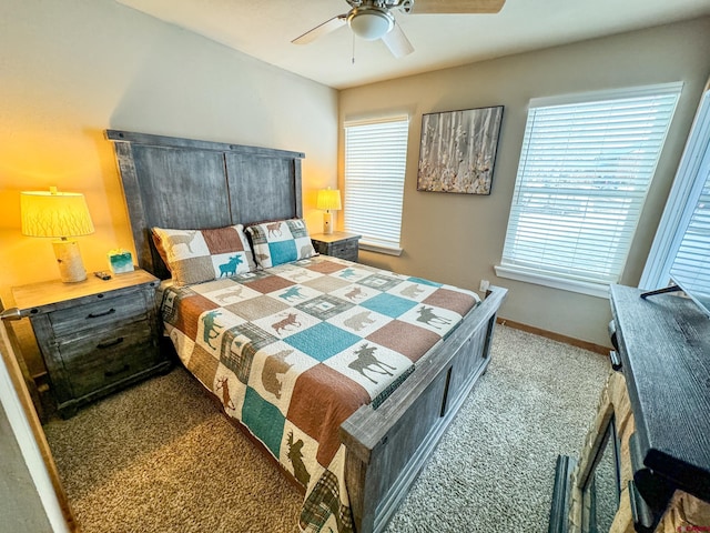 carpeted bedroom with ceiling fan and baseboards