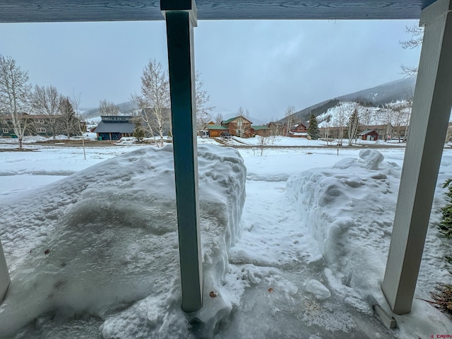 yard covered in snow featuring a mountain view