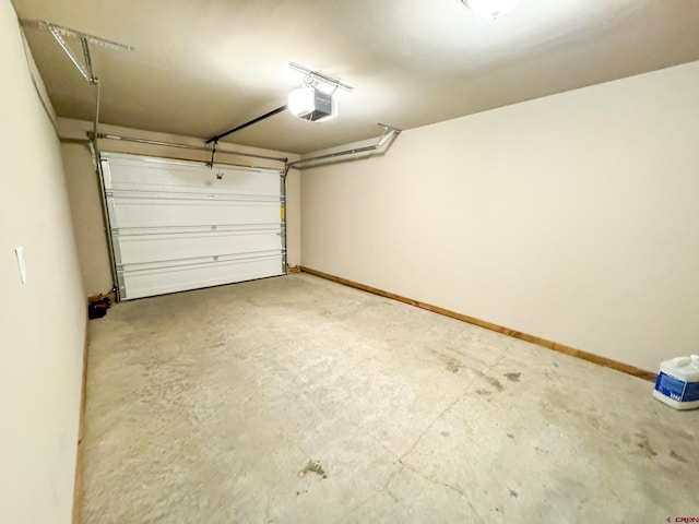 garage with a garage door opener and baseboards