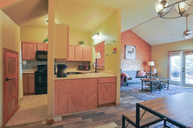 kitchen featuring lofted ceiling, light countertops, decorative backsplash, ceiling fan, and black appliances