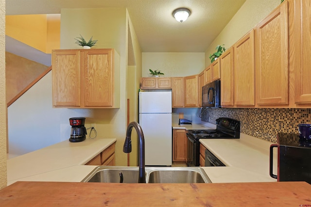 kitchen with light brown cabinets, a sink, light countertops, black appliances, and tasteful backsplash