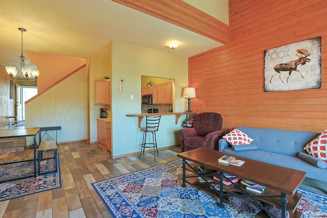 living area with a notable chandelier, wood walls, and wood finished floors