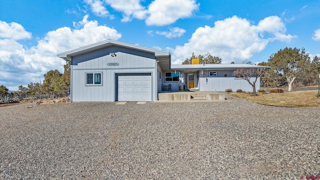 view of front of property with a garage and gravel driveway