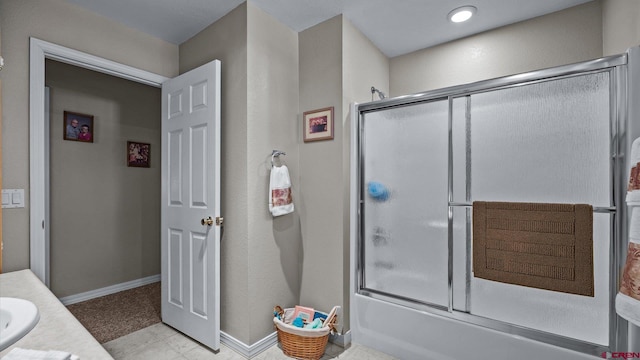 bathroom featuring baseboards, bath / shower combo with glass door, and vanity