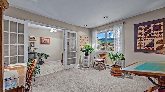 sitting room featuring carpet, french doors, a baseboard heating unit, baseboards, and tile patterned floors