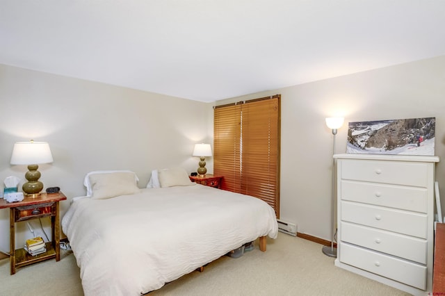 bedroom featuring a baseboard heating unit, light carpet, and baseboards