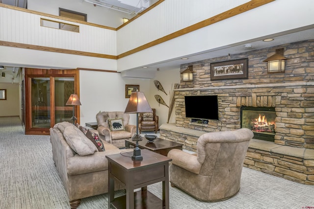 carpeted living area with a high ceiling and a fireplace