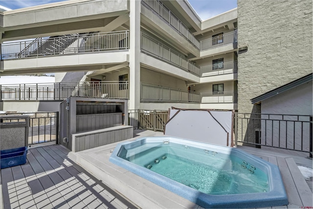 view of swimming pool featuring hot tub deck surround