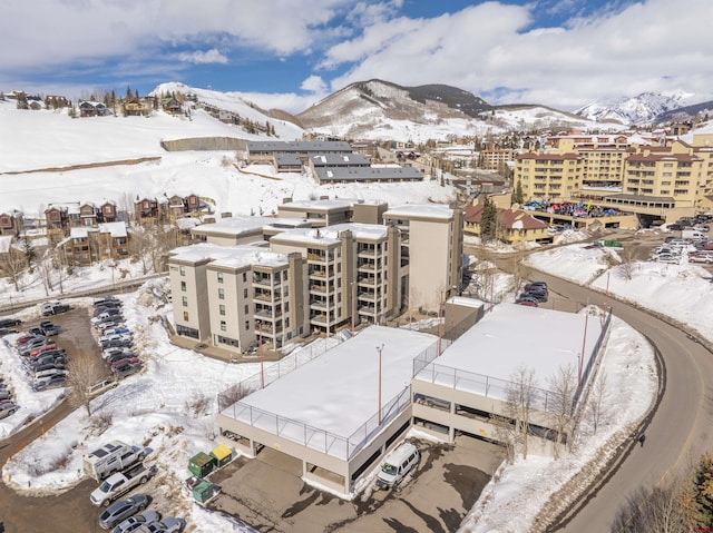 snowy aerial view featuring a mountain view