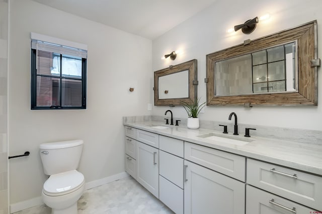 full bathroom featuring toilet, double vanity, baseboards, and a sink