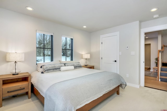 bedroom featuring light carpet, baseboards, and recessed lighting