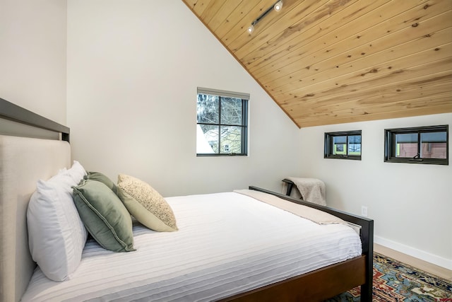 bedroom featuring wood ceiling, vaulted ceiling, and baseboards