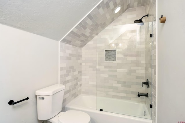 bathroom featuring toilet, shower / tub combination, and lofted ceiling