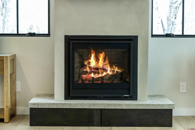 interior details featuring a warm lit fireplace and baseboards