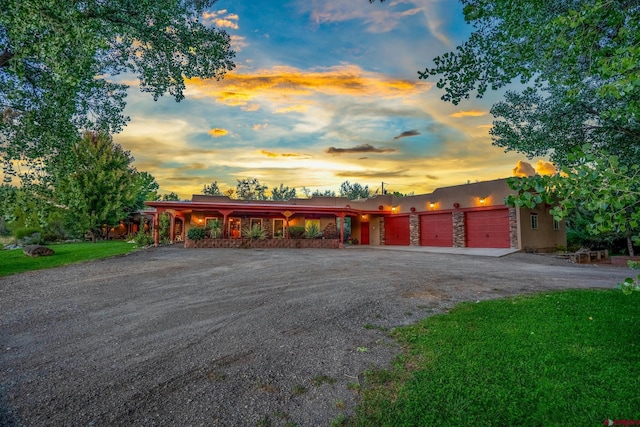 pueblo revival-style home with driveway and an attached garage