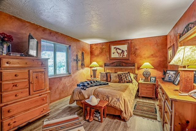 bedroom featuring light wood-style floors and a textured ceiling