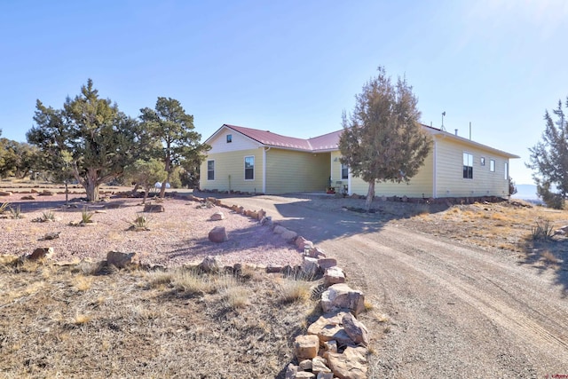 single story home with metal roof and driveway