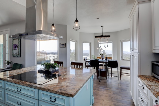 kitchen featuring white cabinets, wood finished floors, island exhaust hood, black electric stovetop, and blue cabinetry