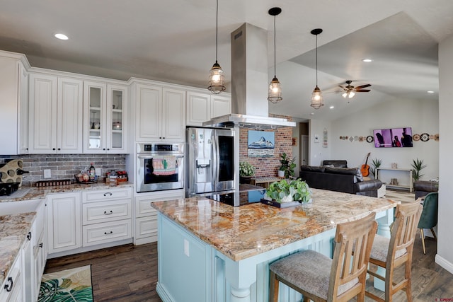 kitchen featuring light stone counters, dark wood-style flooring, island exhaust hood, vaulted ceiling, and stainless steel appliances