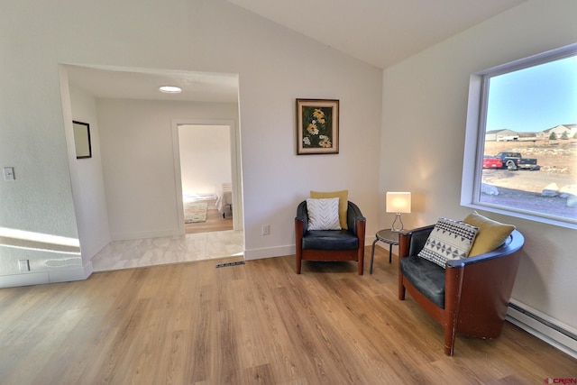 sitting room featuring baseboards, vaulted ceiling, baseboard heating, and wood finished floors