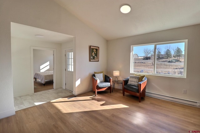 sitting room featuring a baseboard radiator, vaulted ceiling, and wood finished floors