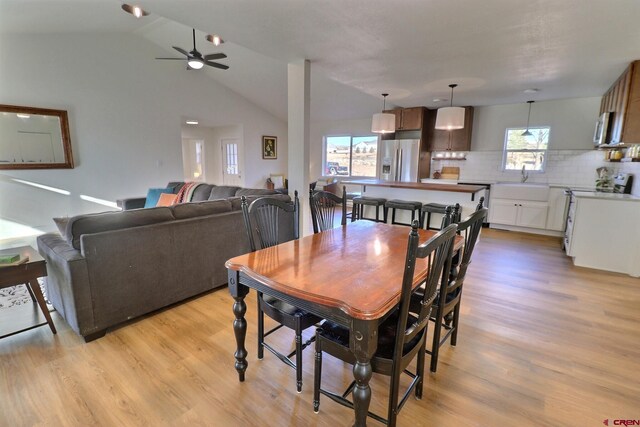 dining area featuring lofted ceiling, ceiling fan, and light wood-style floors