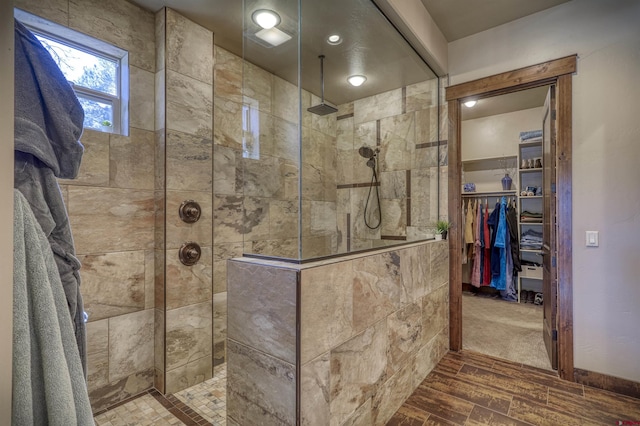 full bathroom featuring a spacious closet and a walk in shower