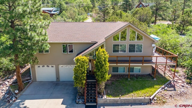 view of front facade with stairs, concrete driveway, and an attached garage