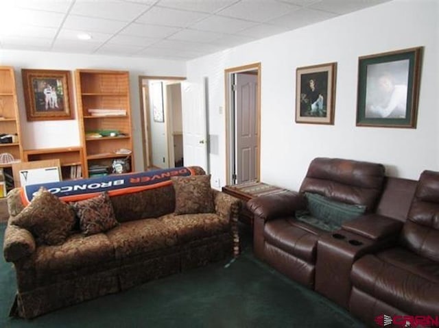 carpeted living area with a paneled ceiling