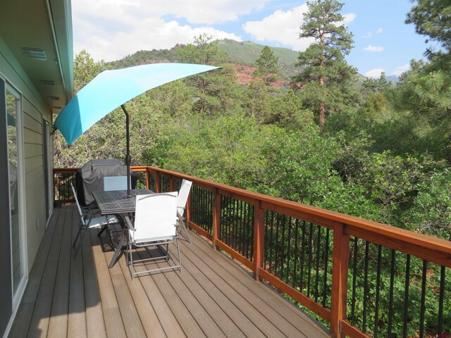 wooden deck with area for grilling and outdoor dining space