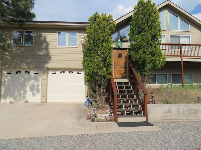view of front of home with a garage, driveway, and stairway