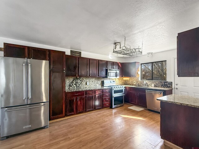 600 Willow Wood Ln, Delta, CO 81416 - kitchen with visible vents, a sink, stainless steel appliances, light wood-type flooring, and backsplash