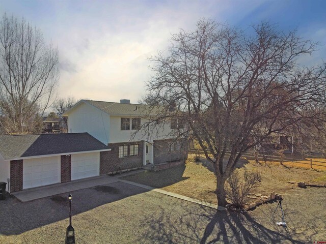600 Willow Wood Ln, Delta, CO 81416 - view of front of property with an attached garage, fence, brick siding, and driveway