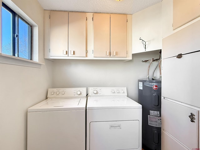 laundry area featuring cabinet space, water heater, a textured ceiling, and independent washer and dryer