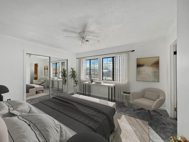 carpeted bedroom with a closet, ceiling fan, a textured ceiling, and baseboards