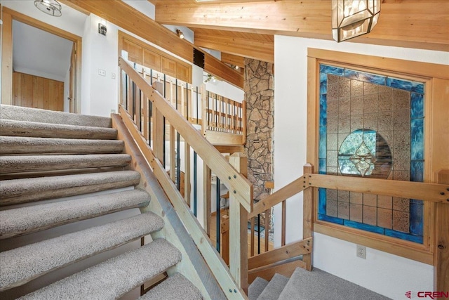 staircase featuring wooden ceiling and beamed ceiling