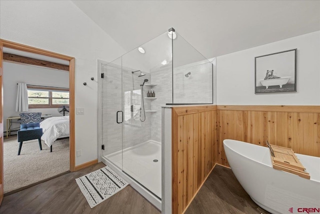 full bath featuring lofted ceiling, wood finished floors, baseboard heating, a soaking tub, and a shower stall