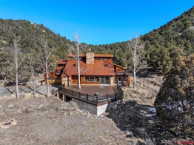 exterior space featuring a chimney and a wooded view