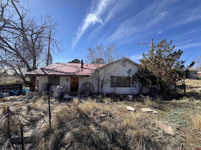 single story home featuring metal roof