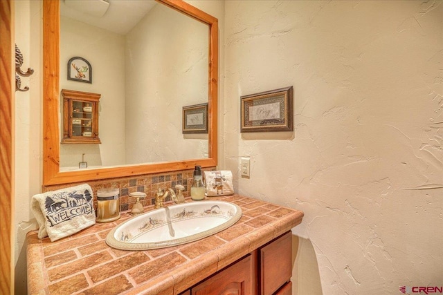 bathroom with a textured wall and vanity