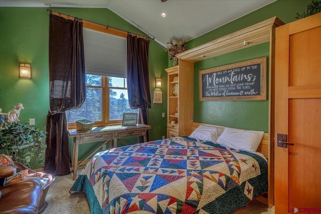 carpeted bedroom with vaulted ceiling and a textured wall