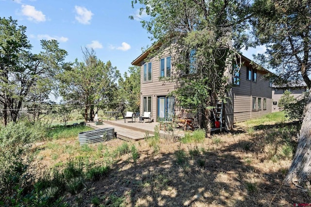 rear view of house featuring a wooden deck