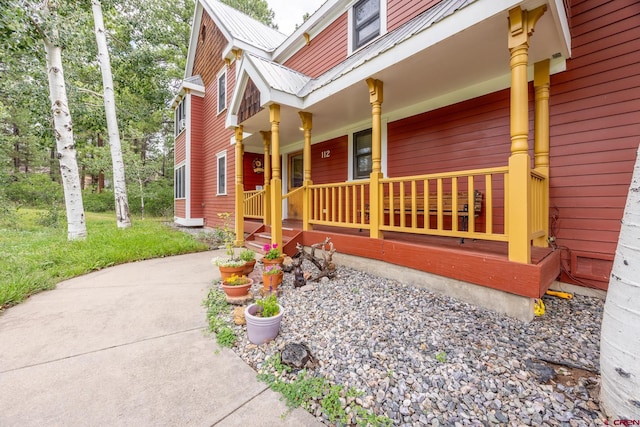 view of side of home featuring covered porch and metal roof