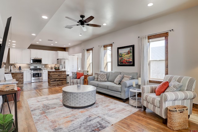 living area with visible vents, a ceiling fan, light wood-style flooring, and recessed lighting