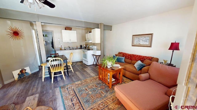 living area featuring a ceiling fan and dark wood-style flooring