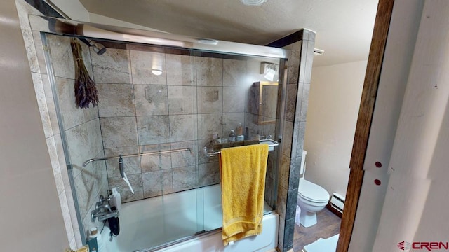 bathroom featuring a baseboard radiator, enclosed tub / shower combo, and toilet