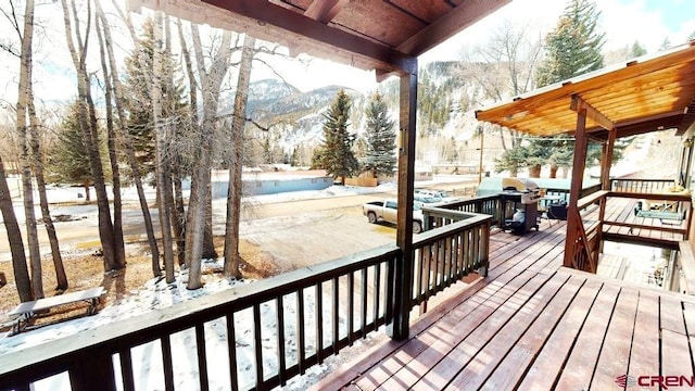 snow covered deck with a mountain view