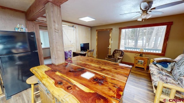 dining space with a barn door, light wood-style flooring, and a healthy amount of sunlight