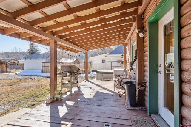 wooden deck featuring a grill and an outdoor structure