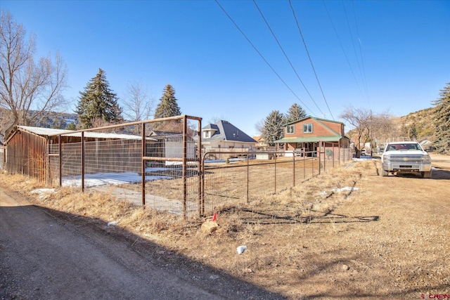 view of yard featuring fence and an outbuilding